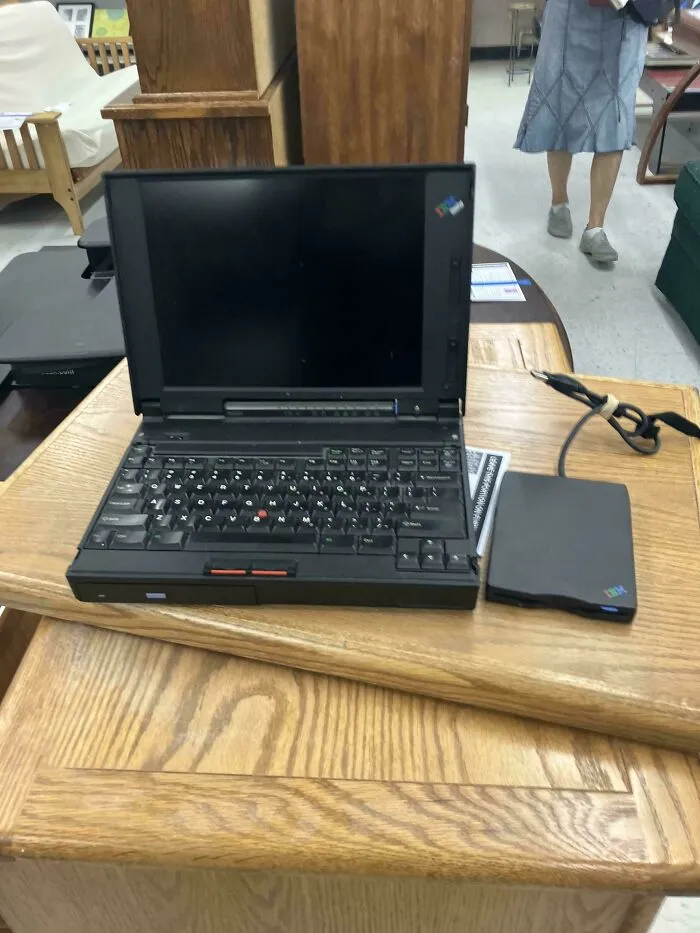 A classic chunky black IBM ThinkPad laptop open on a table, a prime example of vintage tech finds