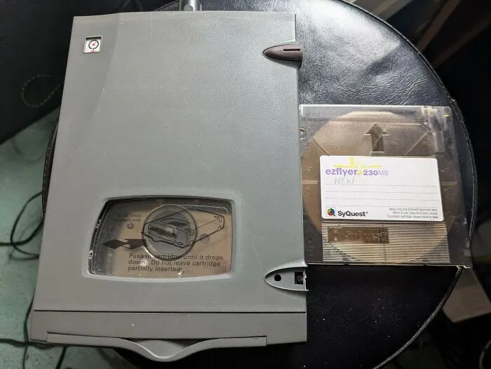 An old gray SyQuest EZFlyer drive and cartridge, representing chunky electronics and vintage tech finds