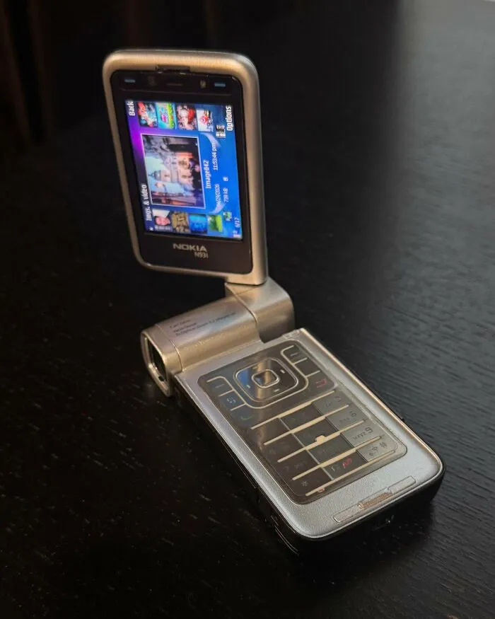 Vintage tech Nokia flip phone with numeric keypad and open rotating screen