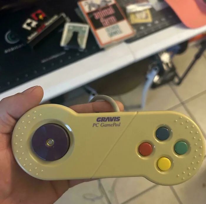 A person holding a classic Gravis PC GamePad representing nostalgic vintage tech accessories