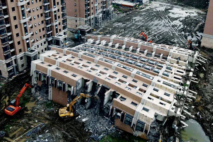 A newly built apartment building collapsed completely on its side, a scene of expensive accidents
