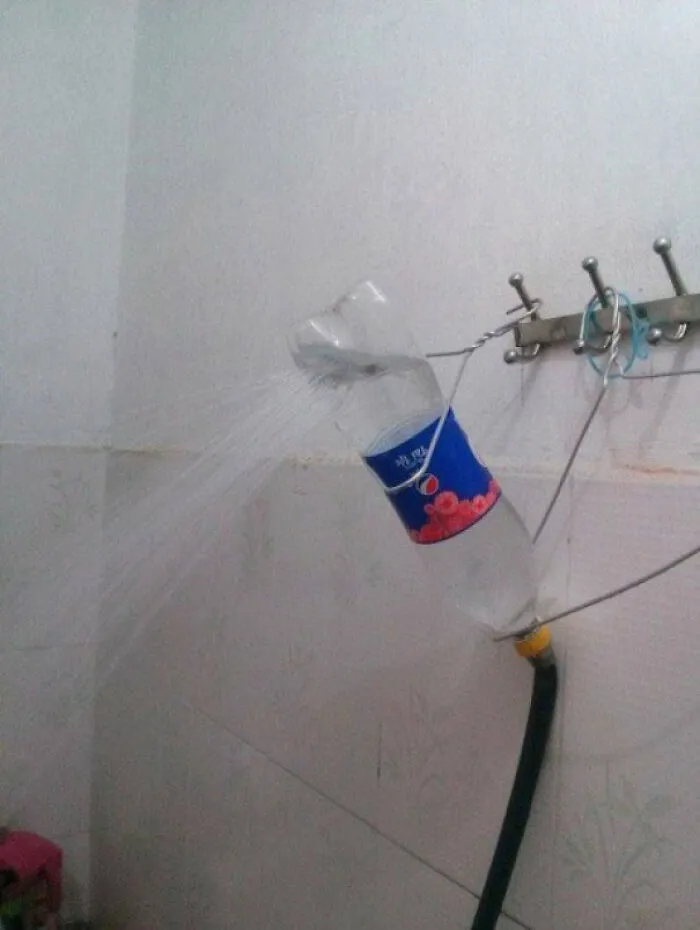Plastic soda bottle used as a makeshift shower head, demonstrating clever redneck fixes.
