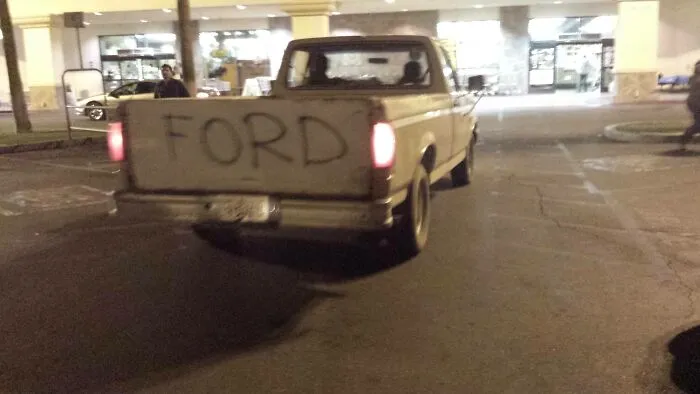 Pickup truck with FORD handwritten on the tailgate as one of many redneck fixes.