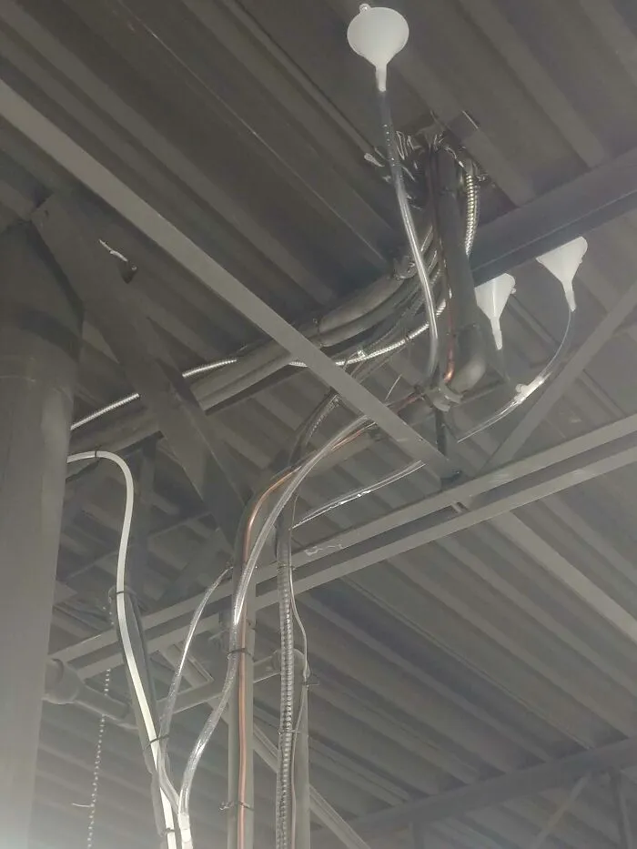 Ceiling pipes with funnels attached to catch leaks, an example of redneck fixes.