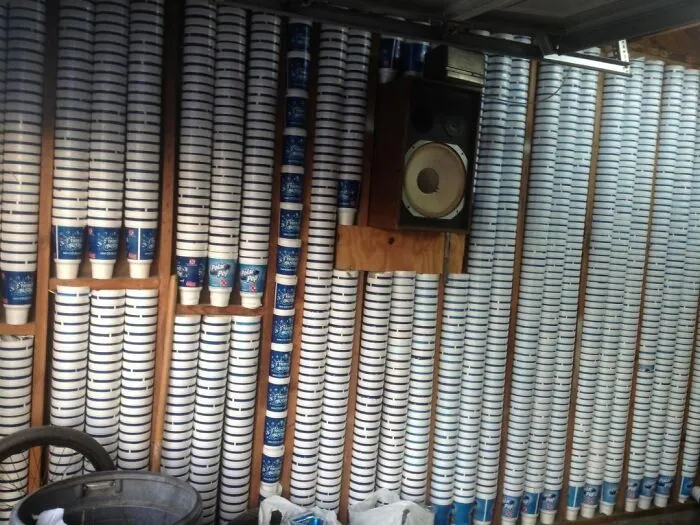 A wall completely lined with stacked plastic cups showing an unusual redneck fix for insulation or storage.
