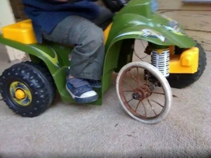 A toy quad bike repaired with a wagon wheel as a redneck fix
