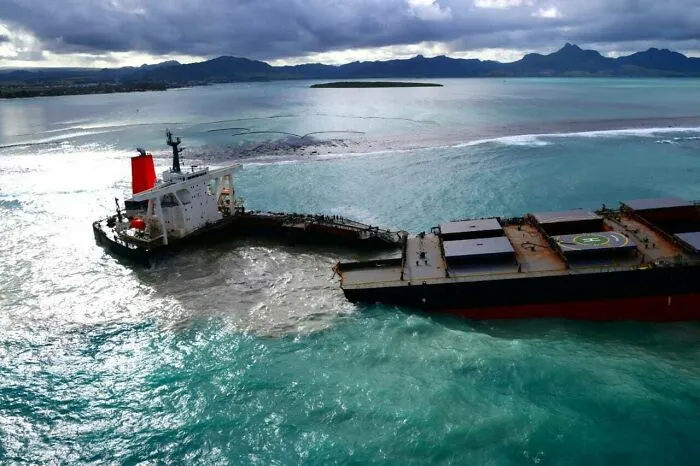 Large cargo ship split in half in the ocean, showing expensive accidents.