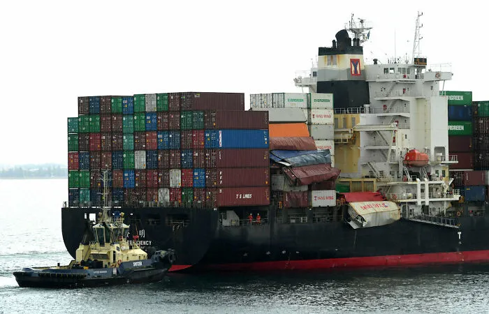 A massive cargo ship with damaged shipping containers, demonstrating expensive accidents.