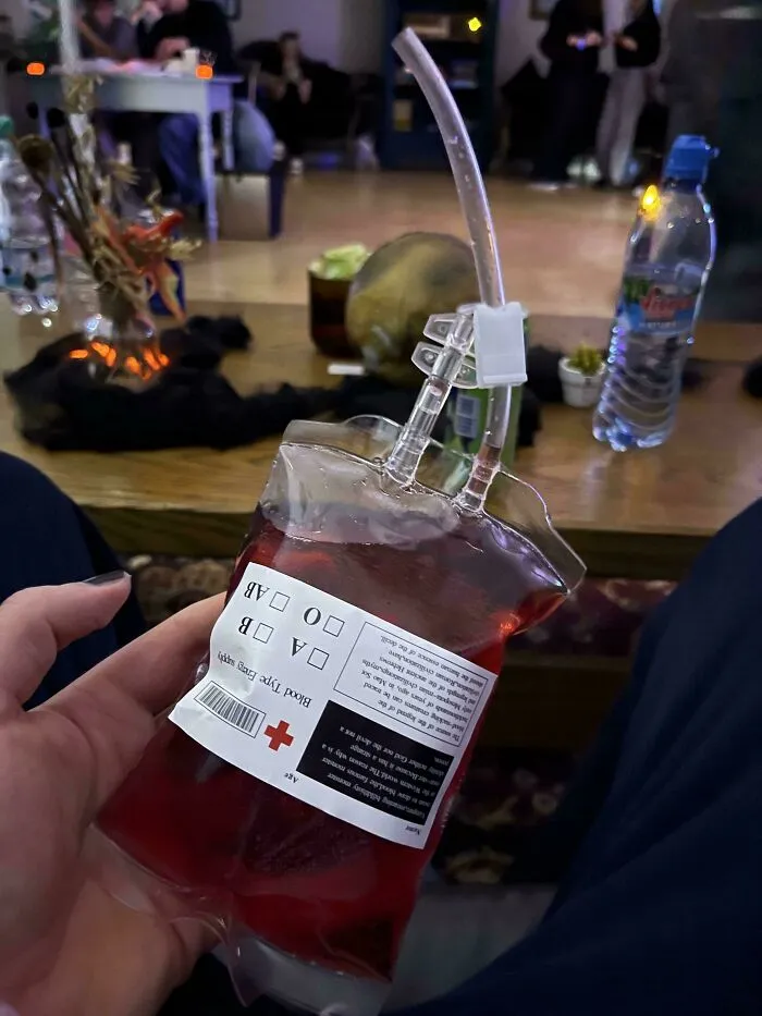 An interesting drink served in a fake blood bag container, showcasing clever ideas for themed party refreshments.