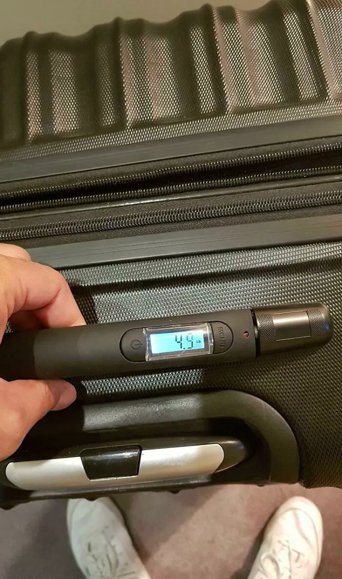 Black suitcase with a built-in digital weight scale showing a satisfying clever idea