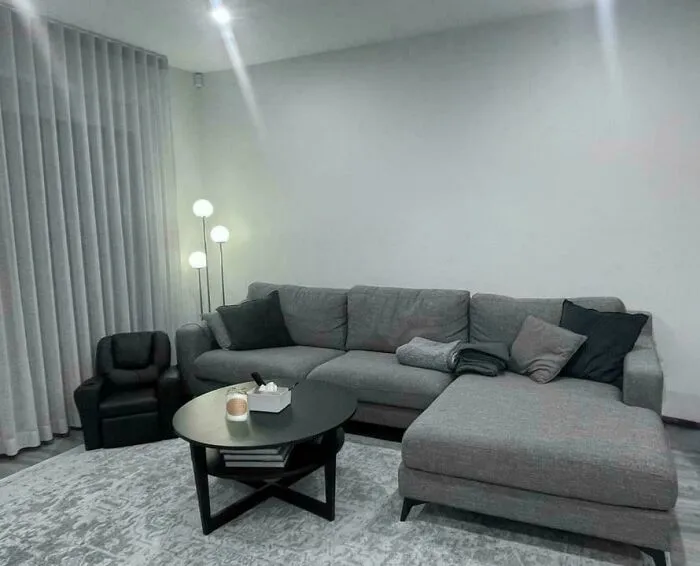 Awkwardly placed tiny chair beside a large sectional illustrating poor interior design decisions