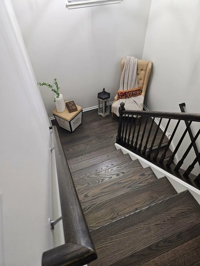 Poor interior design decisions with an awkward reading chair placed at the top of a staircase.