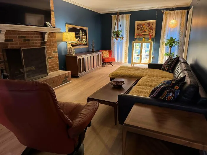 Cosy living room showcase questionable interior design choices with mismatched furniture and dark blue walls