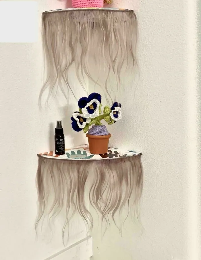 Corner shelf trimmed with hair extensions showcasing unusual interior design choices in home decor
