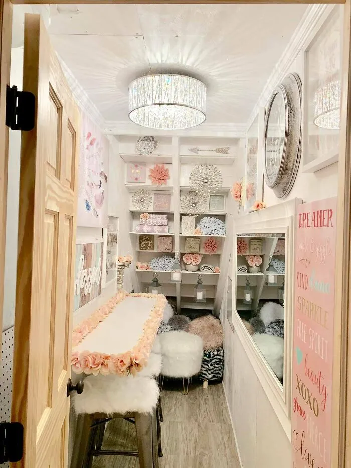 Narrow walk-in closet decorated with excessive pink art and furry stools showcasing poor interior design decisions.
