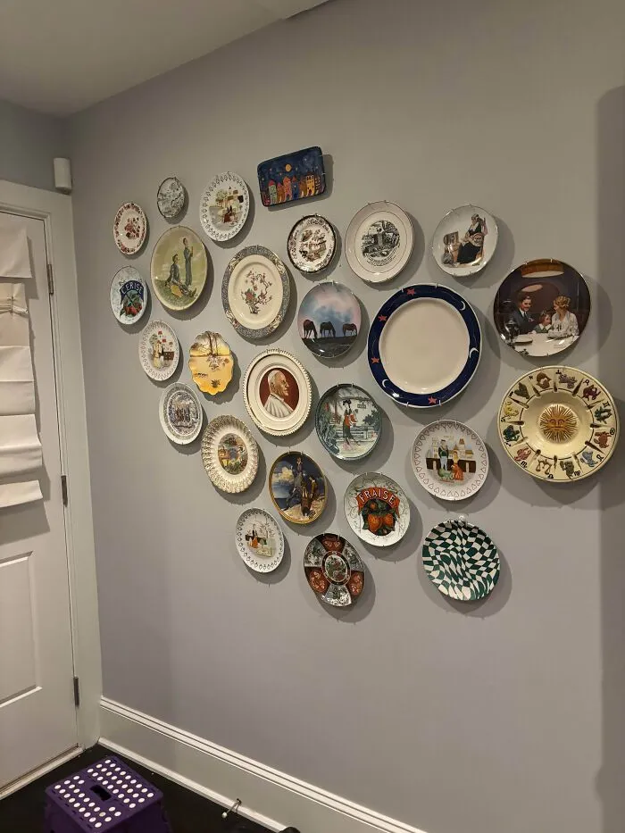 Wall filled with mismatched decorative collector plates hung haphazardly as questionable interior design decisions.