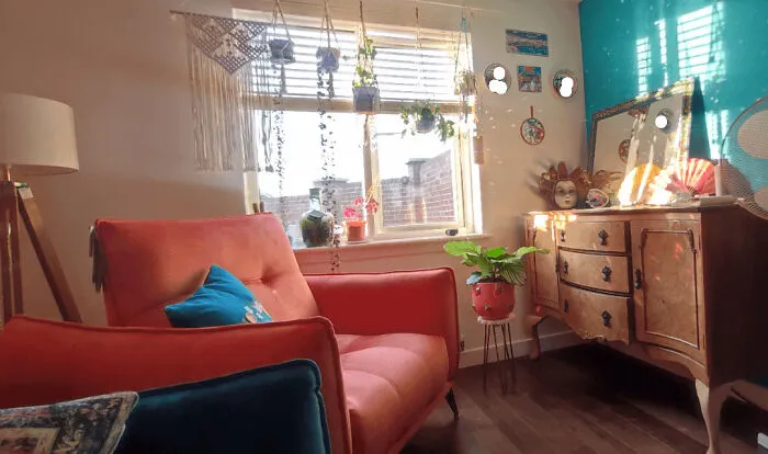 Eclectic living room with orange chair showcasing bold interior design decisions and colorful decor.