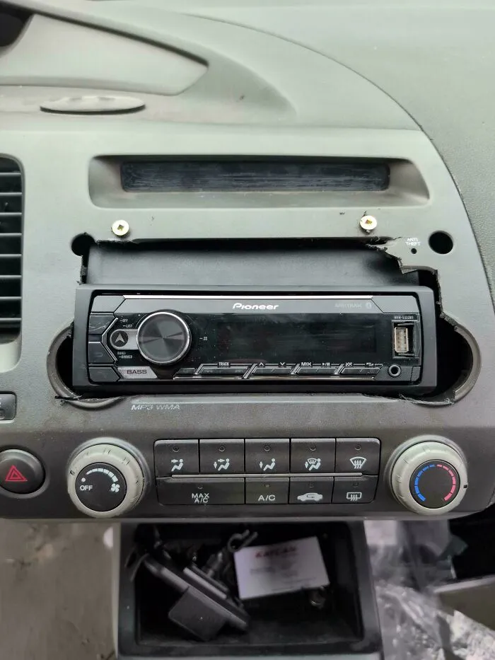 A Pioneer car stereo forcibly installed into a cut-out dashboard, showing one of many funny redneck fixes.