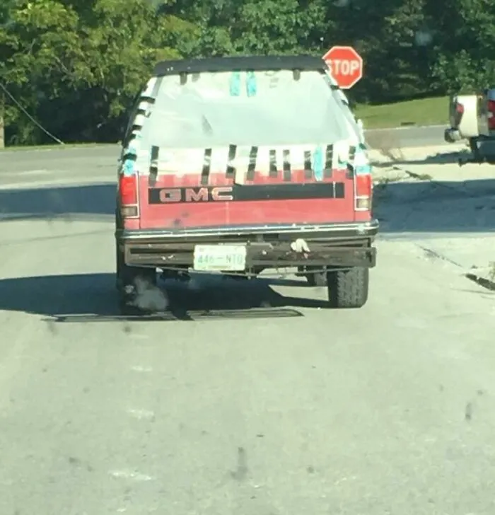 Rear of a GMC truck using plastic wrap and duct tape as a window for redneck fixes.