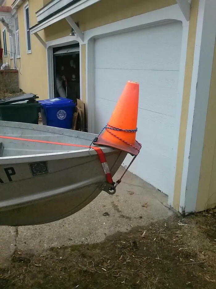 An orange traffic cone attached to a boat bow as part of redneck fixes.