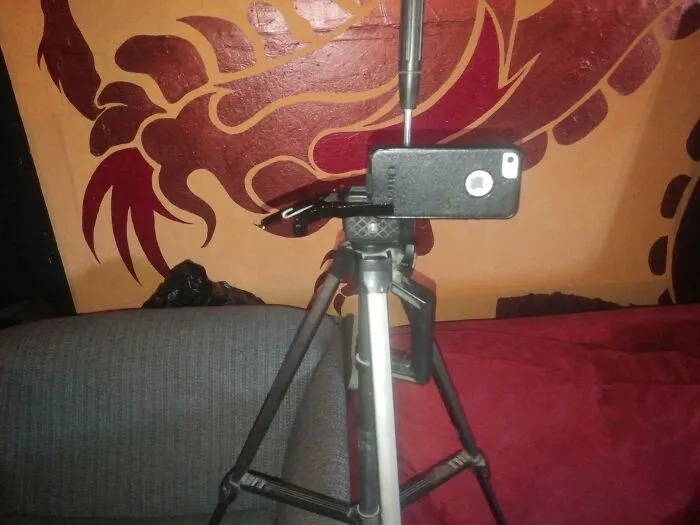 Smartphone mounted on a tripod using screwdriver for redneck fixes.
