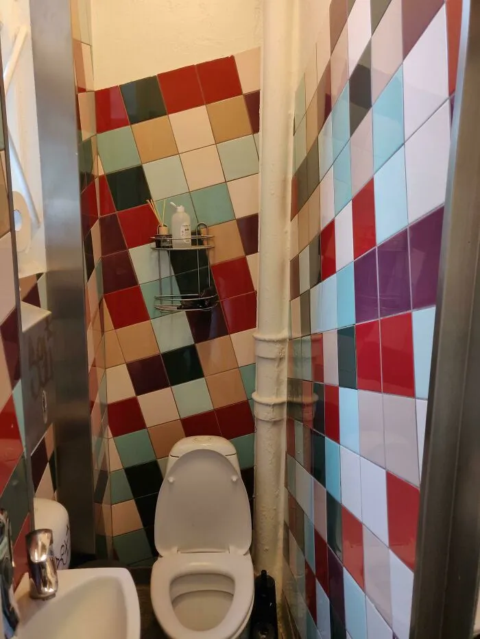 Questionable interior design choice featuring mismatched colorful bathroom wall tiles.
