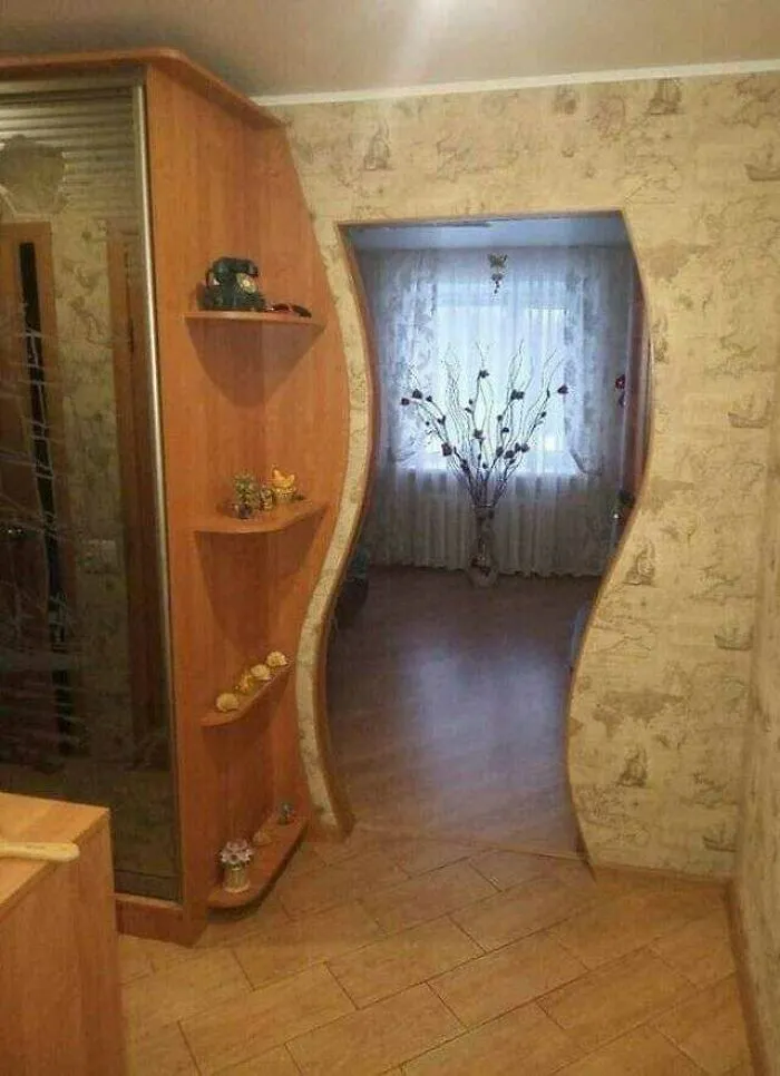 Unusual wavy doorframe creating a bizarre interior design choice in a home entryway.