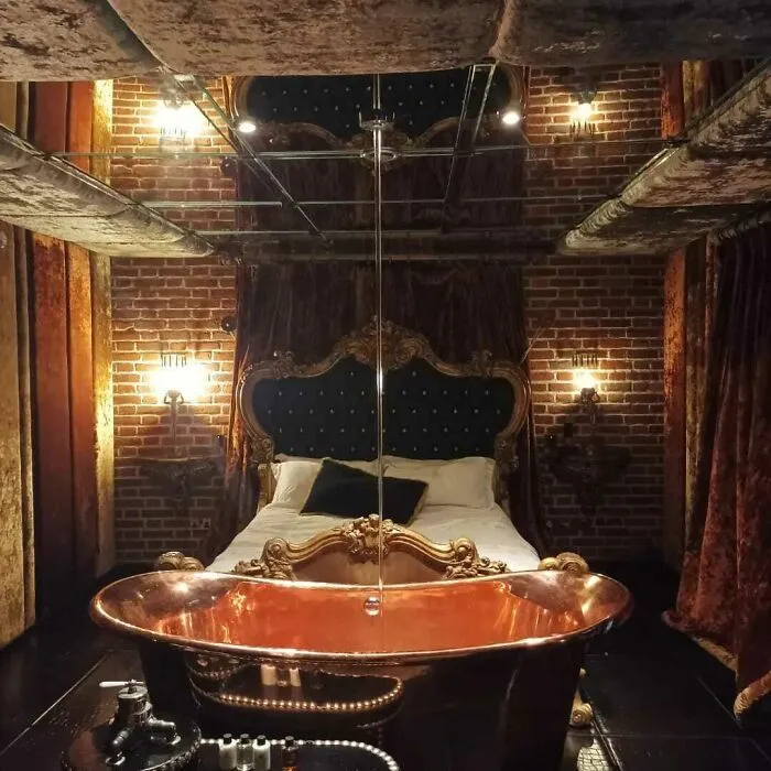 Extravagant bedroom featuring a bathtub next to the bed as a questionable interior design decision.