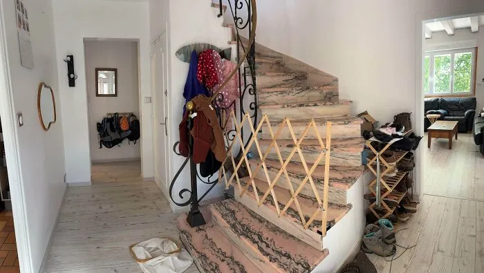 Marble staircase with safety gate in a home hallway, highlighting interior design decisions.
