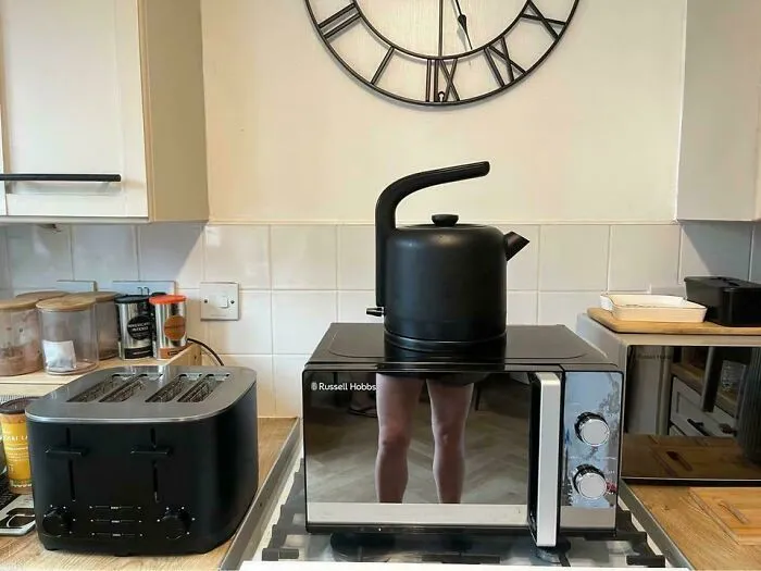 Funny mirror pics showing a reflective microwave door creating a optical illusion with a kettle on top