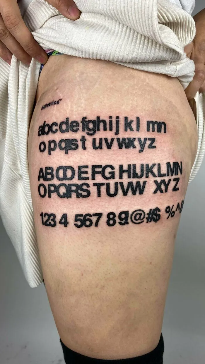 Tattoo of the Helvetica alphabet with overlapping letters as typography fails