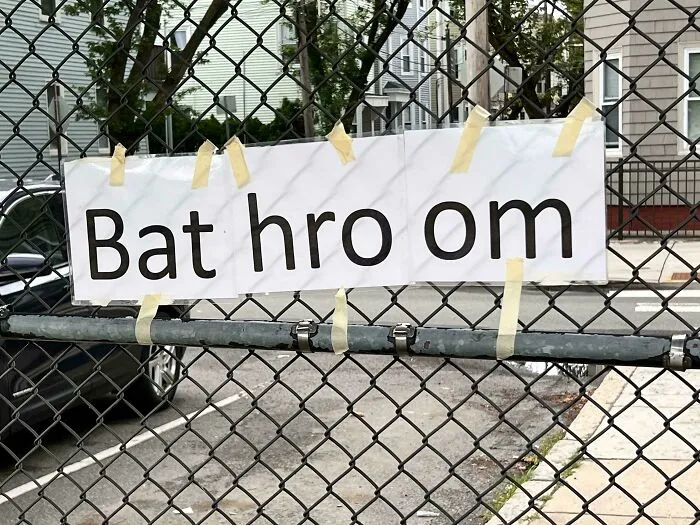 Homemade sign on chainlink fence reading Bat hro om as bad letter spacing example