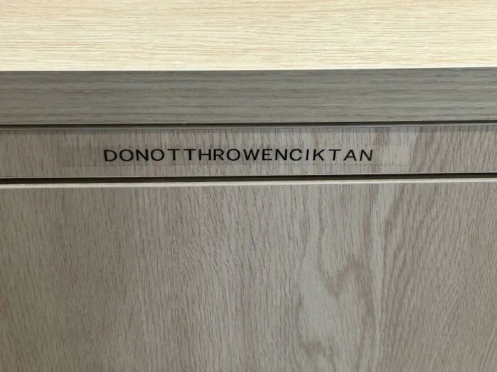 A label on a wooden cabinet drawer showing DONOTTHROWENCIKTAN as an example of typography fails