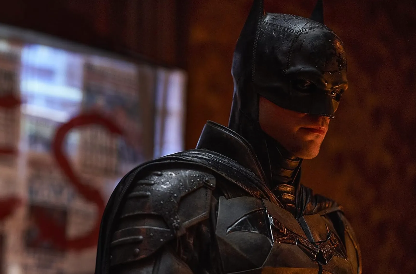 The actor Robert Pattinson as Batman in a dark, atmospheric setting.