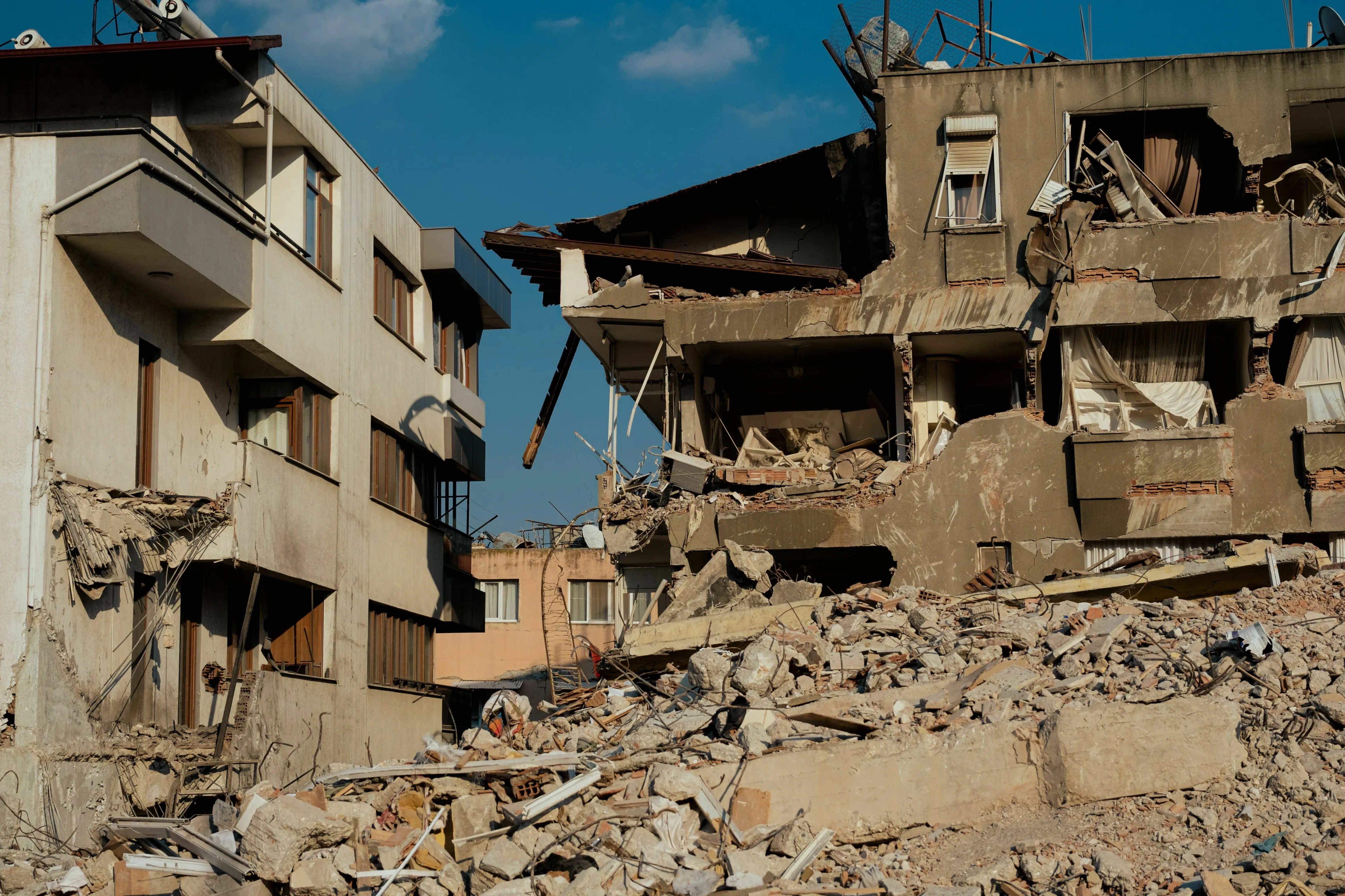 Dilapidated and collapsed concrete buildings showing the aftermath of a powerful earthquake.