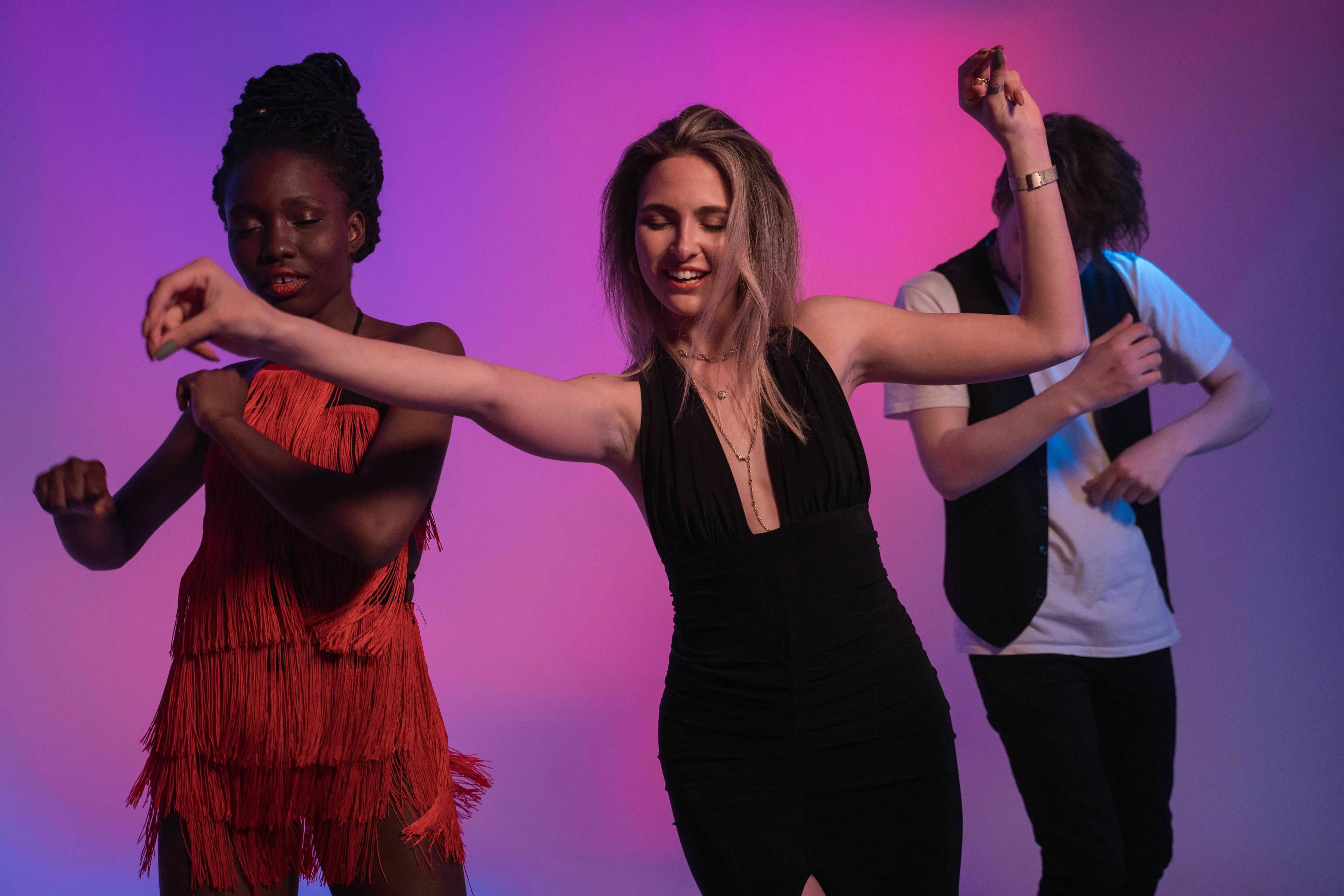 A group of friends dancing joyfully under purple light, inspired by the song Dancing Queen