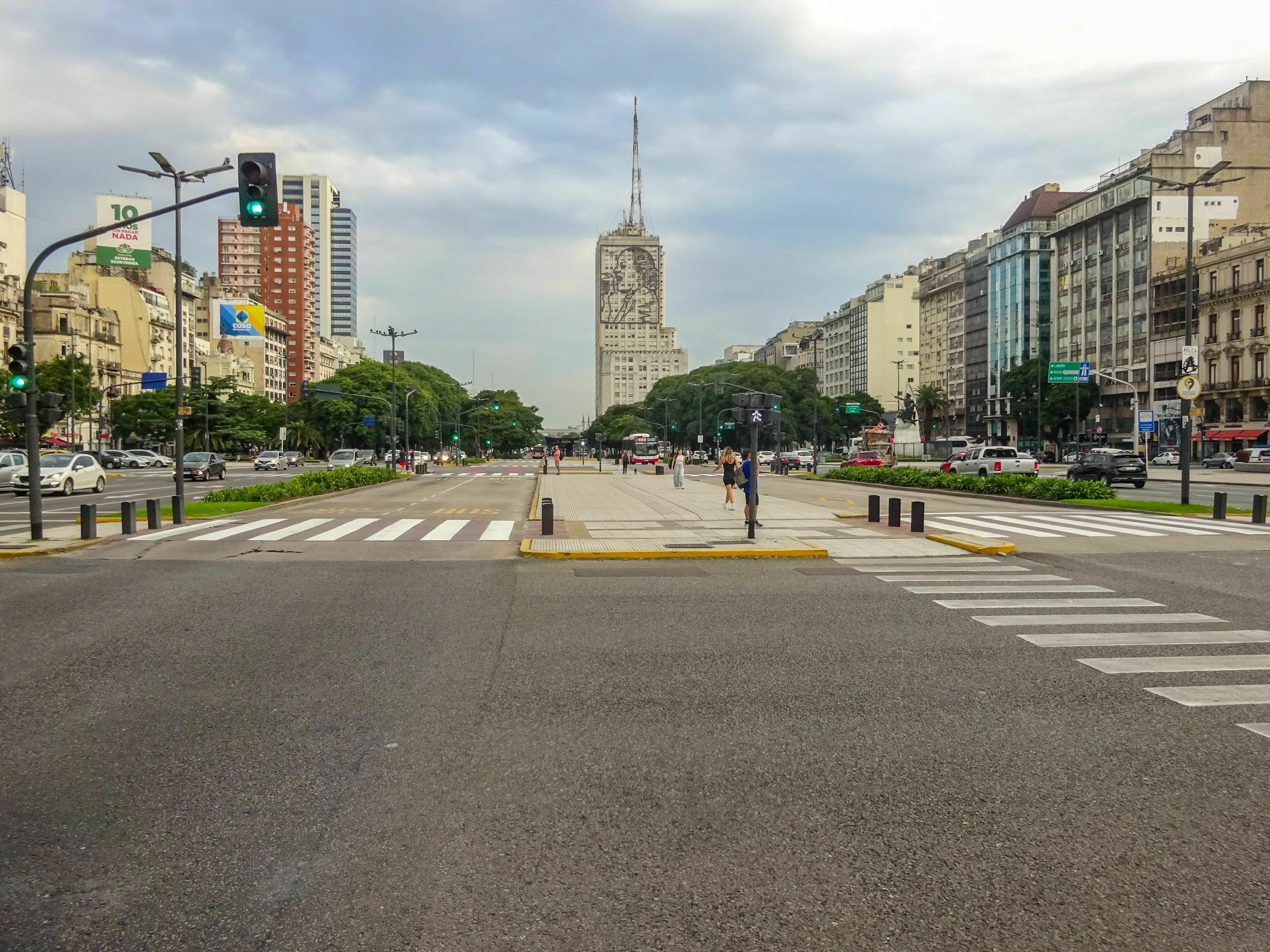 A wide avenue in Buenos Aires with crosswalks and skyscrapers