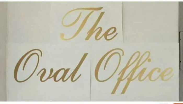 Golden decals for The Oval Office showcasing uneven letter spacing.