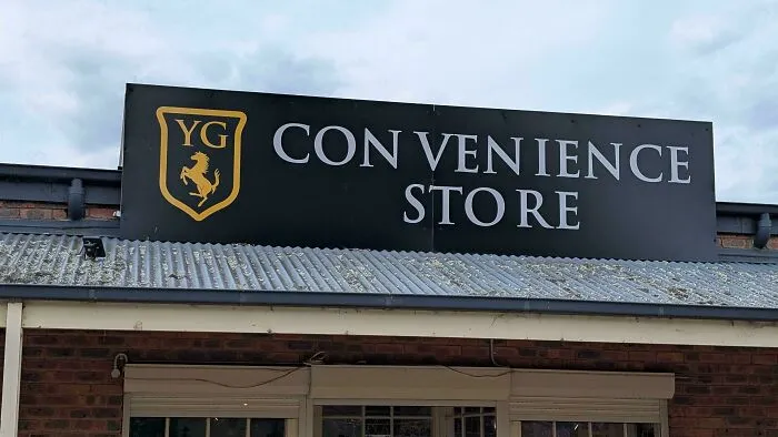 A convenience store sign showing a typography fail with bad letter spacing in convenience and store