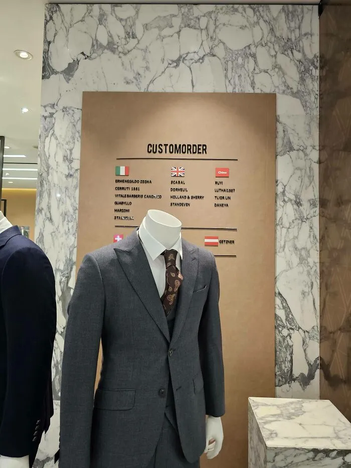 A custom order sign on a clothing store wall with bad letter spacing making it read customorder