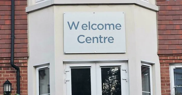 A Welcome Centre building sign with a typography fail showing uneven letter spacing on the letter W