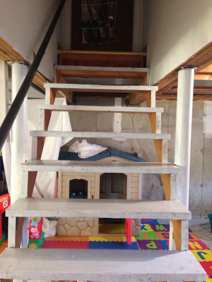 An unstable basement staircase with gaps, showing questionable decisions in home design.