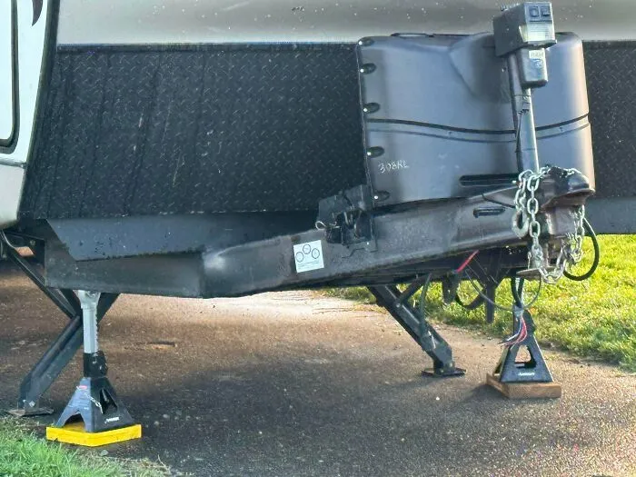 An RV jack stand setup that is a questionable decision with multiple stabilizer jacks balanced on each other.