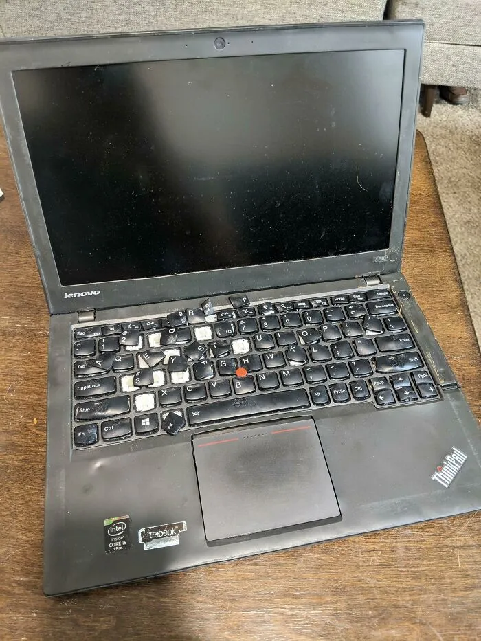 A Lenovo ThinkPad laptop with broken and misplaced keyboard keys demonstrating highly questionable decisions.