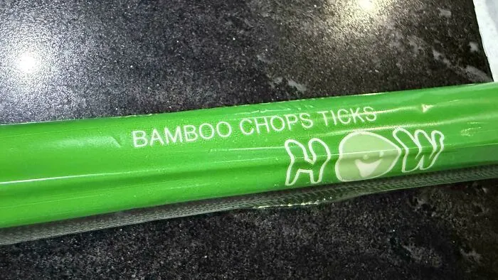 Green packaging for chopsticks with improper spacing on BAMBOO CHOPS TICKS, demonstrating typography fails.