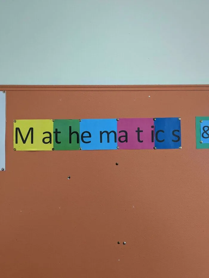 School wall display showcasing bad letter spacing split across colored paper panels