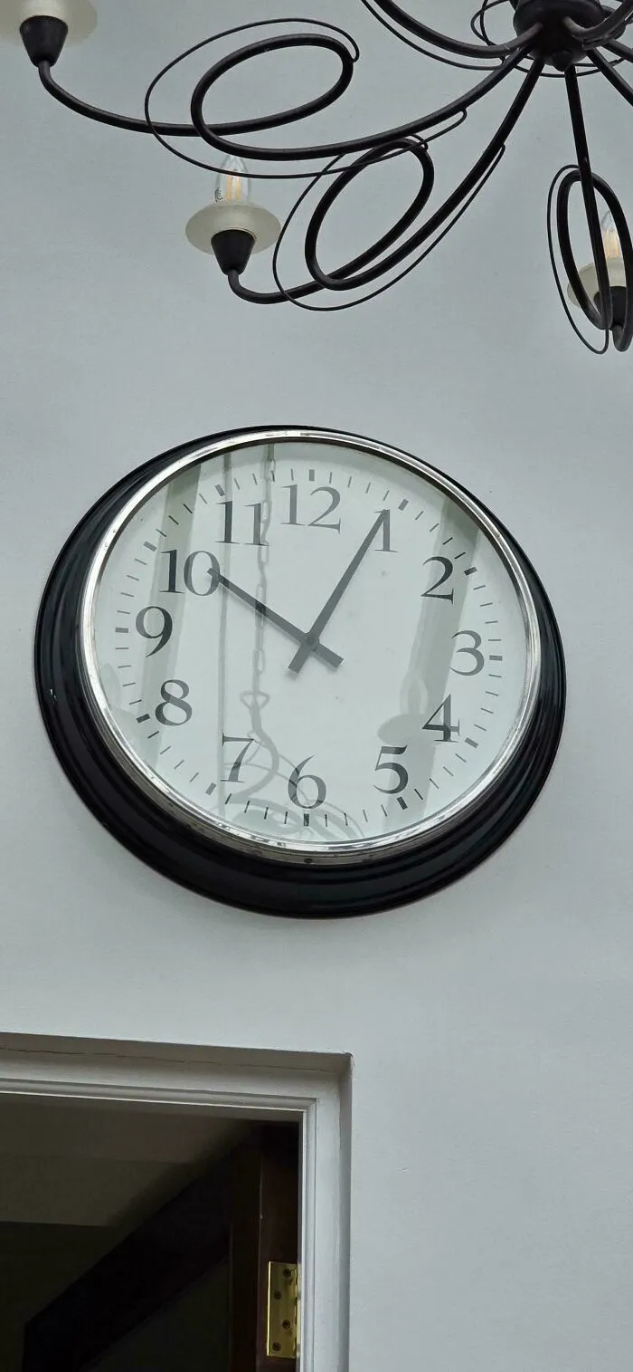 Large wall clock with poor letter spacing on the numbers, representing a typography fail.