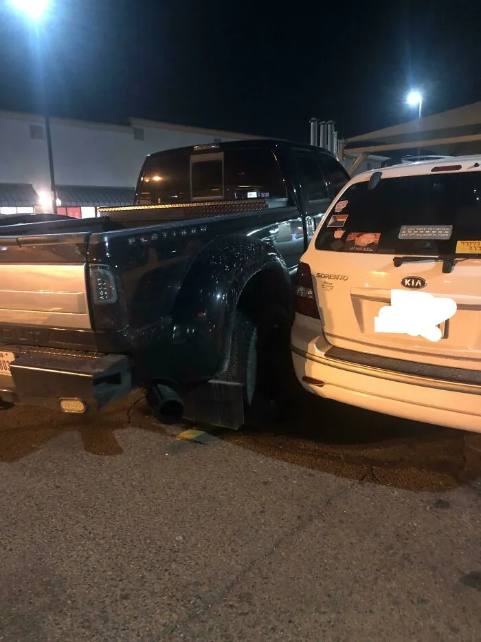 A truck parked so close to a car it illustrates questionable parking decisions