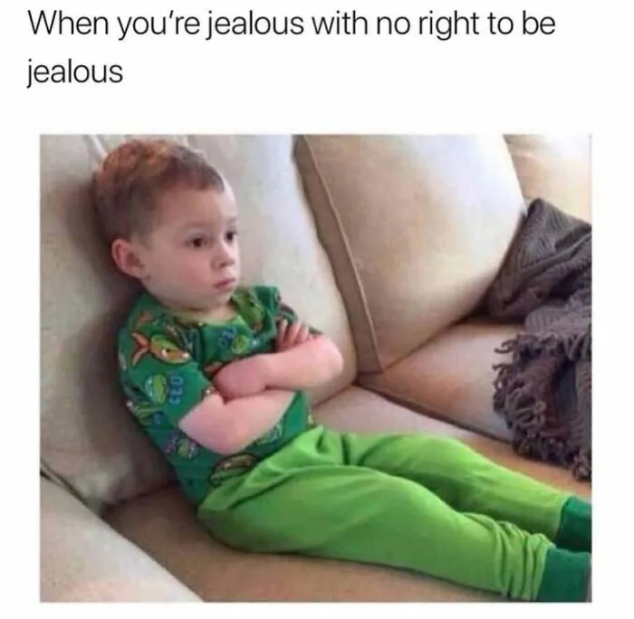 Funny memes with a jealous kid sitting on a sofa with arms crossed.