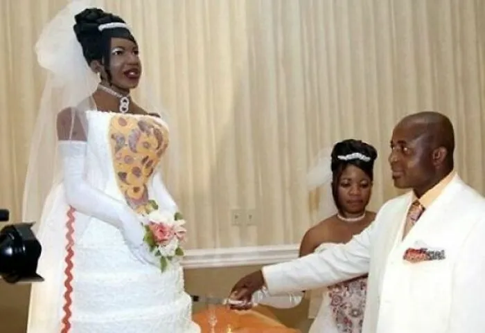 Groom standing next to a life-size bride cake during questionable wedding moments